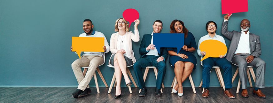 A diverse group of people smiling while holding colourful speech bubbles